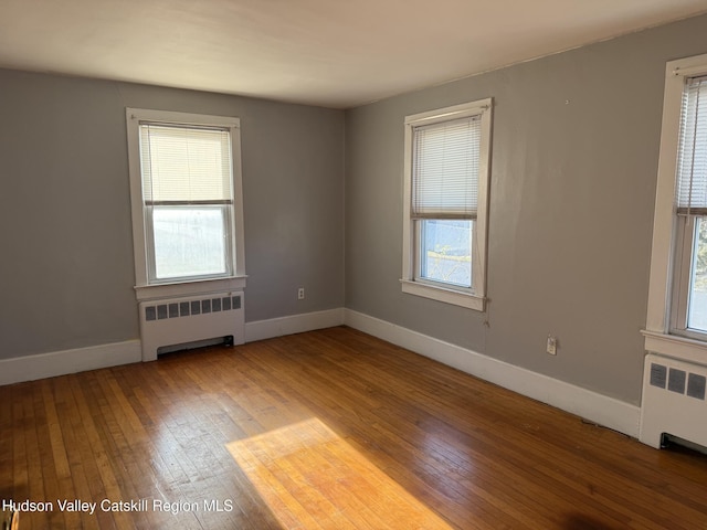 empty room with radiator heating unit and wood-type flooring