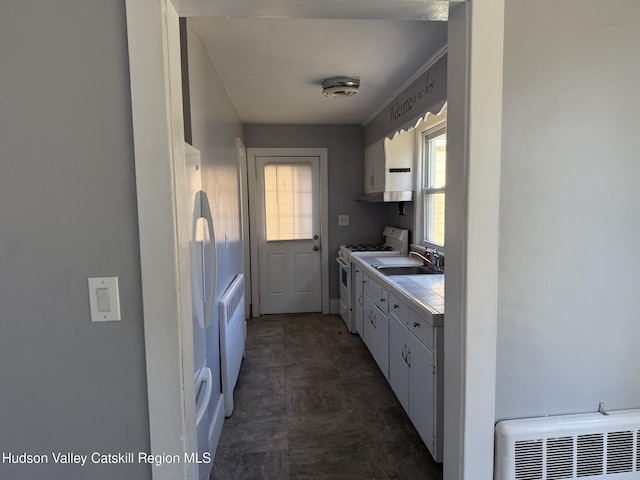 kitchen featuring white cabinetry, white appliances, and sink