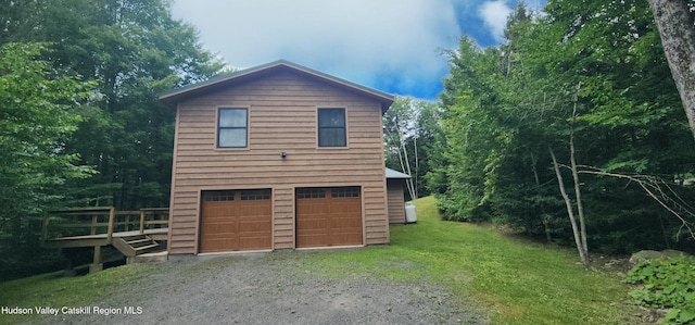 69 June Lodge Dr, Hunter, NY 12442 - view of side of property with driveway, an attached garage, and a yard