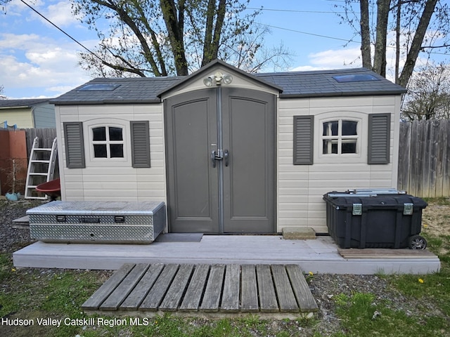 view of shed featuring fence