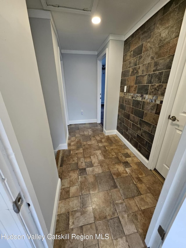 corridor featuring ornamental molding, recessed lighting, stone tile flooring, and baseboards