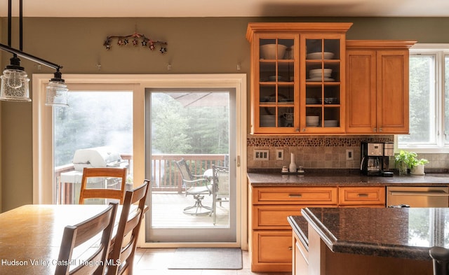 214 Wright Rd, Kerhonkson, NY 12446 - kitchen featuring stainless steel dishwasher, brown cabinets, glass insert cabinets, dark stone counters, and backsplash