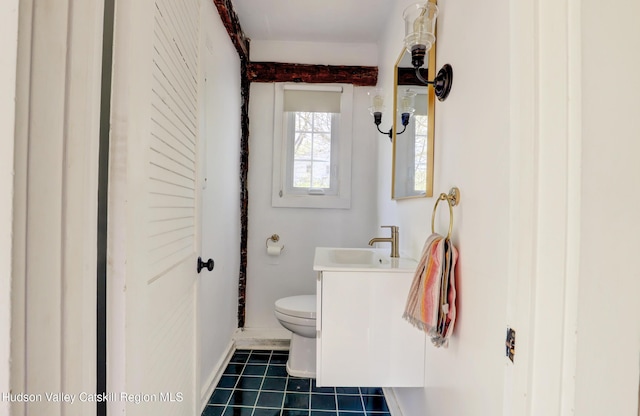 bathroom with toilet, baseboards, tile patterned flooring, and vanity