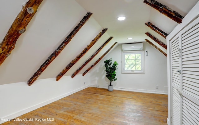 bonus room with baseboards, light wood finished floors, lofted ceiling, and a wall mounted AC