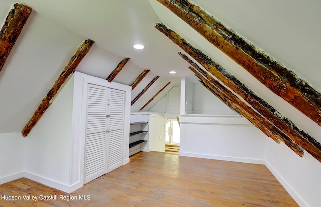 bonus room with recessed lighting, baseboards, lofted ceiling with beams, and wood finished floors