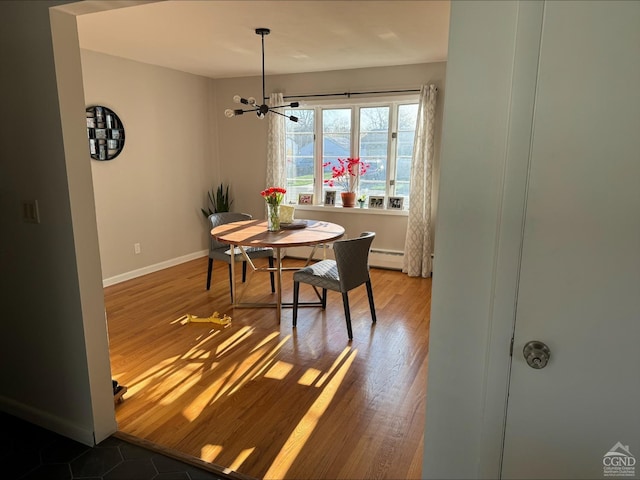 25 Joslen Pl, Hudson, NY 12534 - dining room with a chandelier, wood finished floors, baseboards, and a baseboard heating unit
