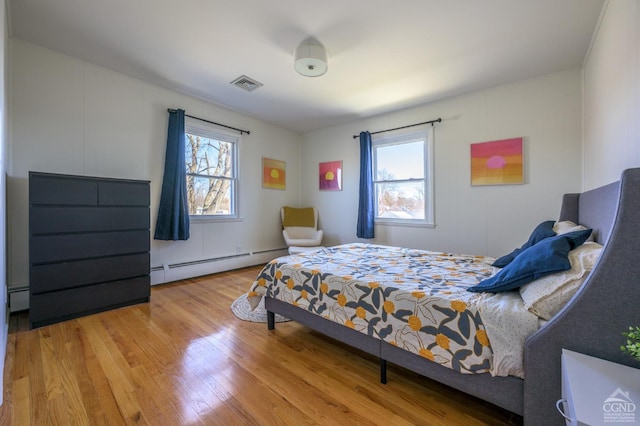 25 Joslen Pl, Hudson, NY 12534 - bedroom with baseboard heating, multiple windows, and wood finished floors