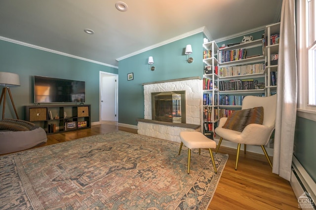 25 Joslen Pl, Hudson, NY 12534 - living area featuring a baseboard heating unit, ornamental molding, wood finished floors, a stone fireplace, and baseboards