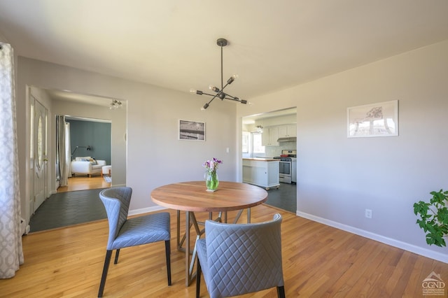 25 Joslen Pl, Hudson, NY 12534 - dining space with light wood finished floors, a chandelier, and baseboards