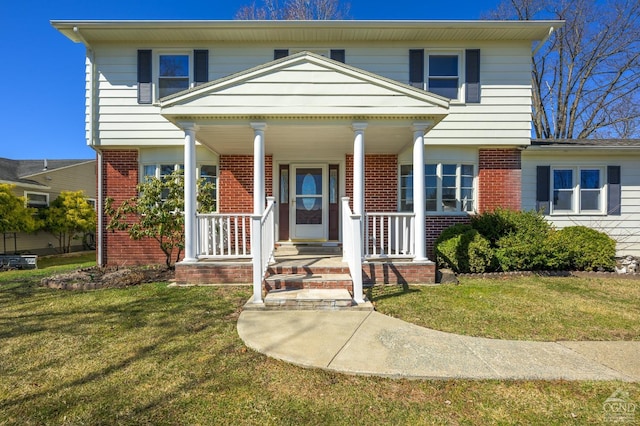 25 Joslen Pl, Hudson, NY 12534 - view of front of home with brick siding, a front lawn, and covered porch