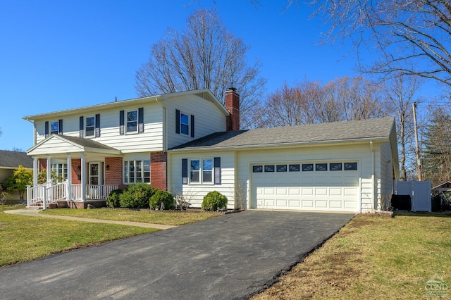 25 Joslen Pl, Hudson, NY 12534 - view of front facade with asphalt driveway, a garage, a chimney, and a front lawn