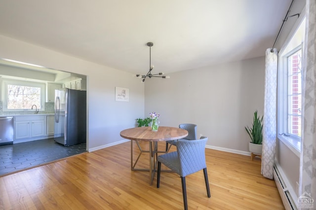 25 Joslen Pl, Hudson, NY 12534 - dining area with a chandelier, a baseboard radiator, light wood-type flooring, and baseboards