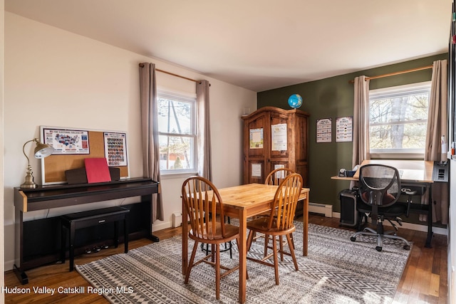 dining space featuring wood finished floors, baseboards, and a baseboard radiator