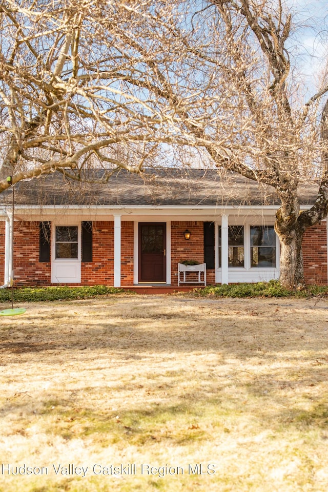 view of front of house featuring brick siding and a porch