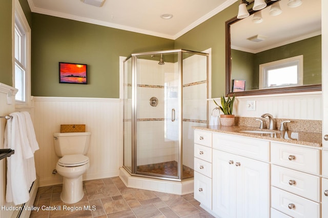 full bathroom featuring vanity, toilet, a wainscoted wall, and a stall shower