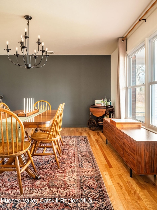 dining room with a notable chandelier and light wood finished floors