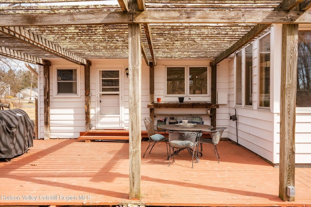 wooden deck with grilling area and a pergola