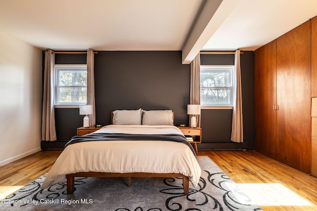 bedroom featuring baseboards and light wood-style floors