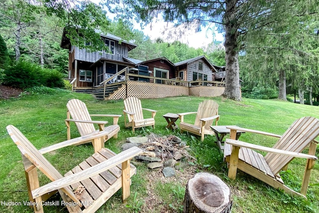 view of yard featuring a deck and a fire pit