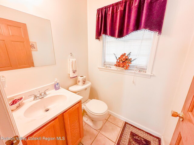 bathroom featuring tile patterned flooring, vanity, and toilet