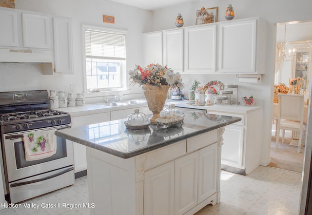 kitchen featuring custom exhaust hood, a center island, white cabinets, sink, and stainless steel gas range