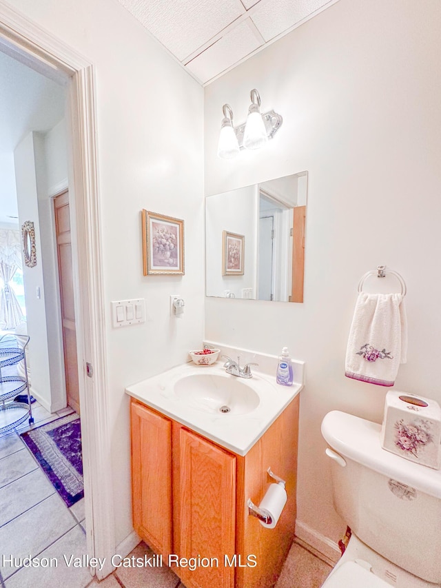 bathroom with tile patterned flooring, vanity, and toilet