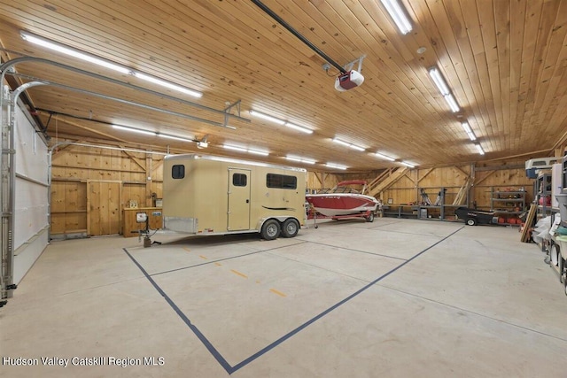 garage with wooden walls, wooden ceiling, and a garage door opener