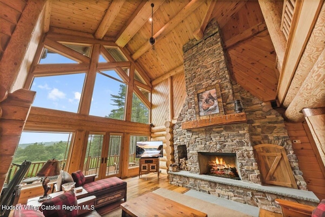 unfurnished living room with wood ceiling, beam ceiling, hardwood / wood-style flooring, high vaulted ceiling, and a fireplace