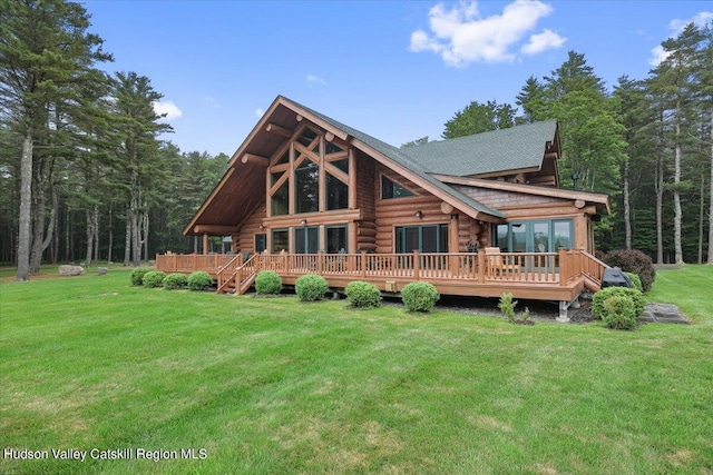 rear view of house featuring a deck and a lawn