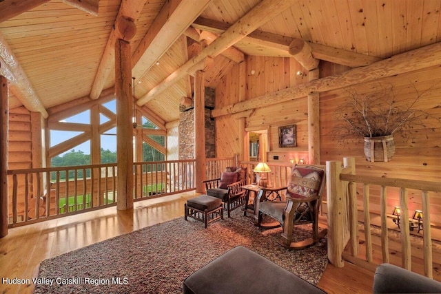 living area featuring beamed ceiling, hardwood / wood-style floors, high vaulted ceiling, and wooden ceiling