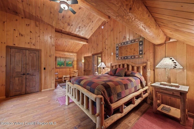 bedroom with hardwood / wood-style floors, wooden ceiling, lofted ceiling with beams, wooden walls, and ceiling fan