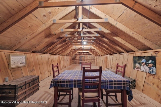 dining area featuring wood walls, light hardwood / wood-style flooring, wooden ceiling, and vaulted ceiling