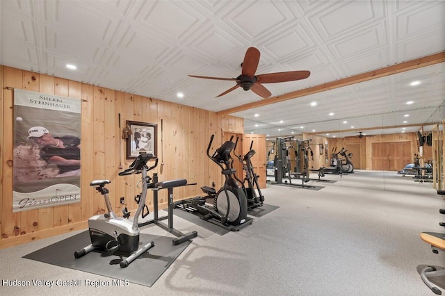 gym featuring ceiling fan, carpet floors, and wooden walls