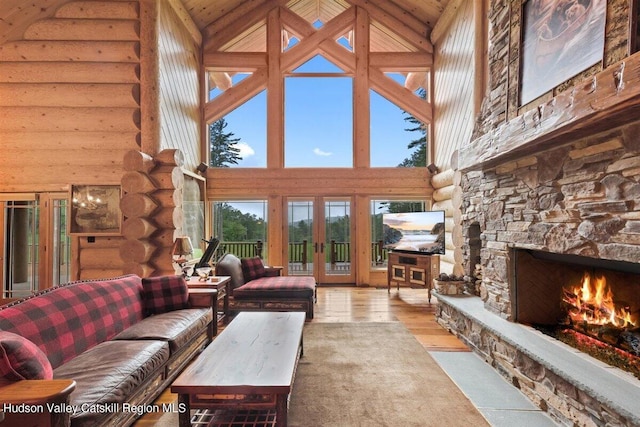 living room featuring a stone fireplace, rustic walls, and high vaulted ceiling