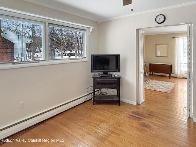 living room with light wood-style flooring, a baseboard heating unit, baseboards, and ornamental molding