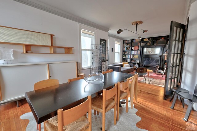 dining space with crown molding and wood finished floors