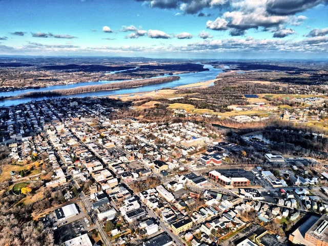 aerial view of property and surrounding area with a large body of water and nearby suburban area