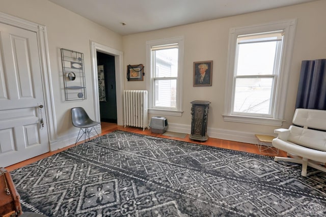 sitting room featuring radiator heating unit, wood finished floors, and baseboards
