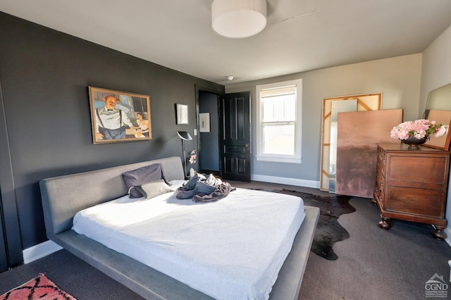 bedroom with baseboards and carpet