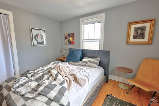 bedroom featuring wood-type flooring and baseboards