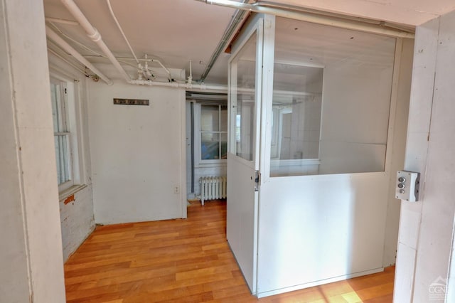 hall with radiator and wood finished floors