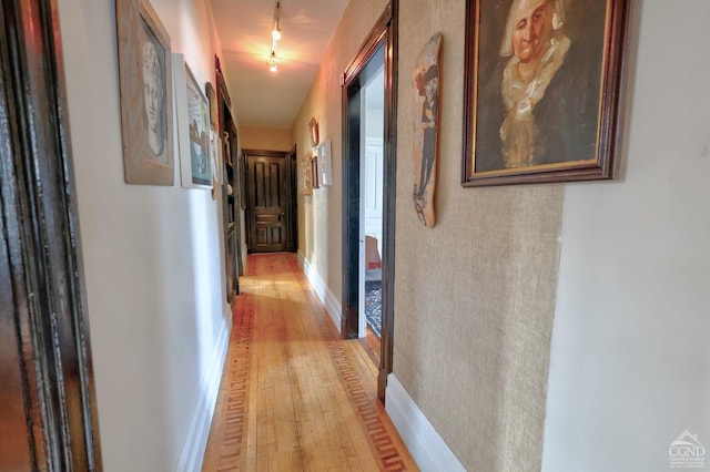 hallway featuring light wood-style floors and baseboards