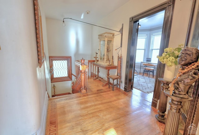 hallway featuring wood-type flooring and an upstairs landing