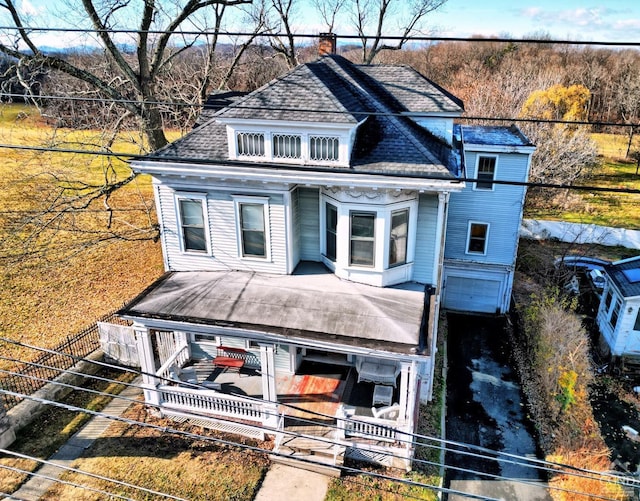 view of front of home featuring a chimney, fence, a shingled roof, and stairway