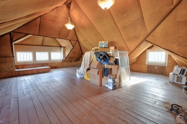 bonus room with vaulted ceiling, hardwood / wood-style flooring, and wooden walls