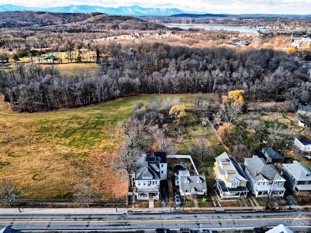aerial view of residential area featuring a mountainous background and a tree filled landscape