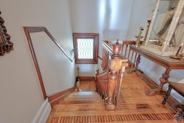 stairs with wood finished floors and baseboards