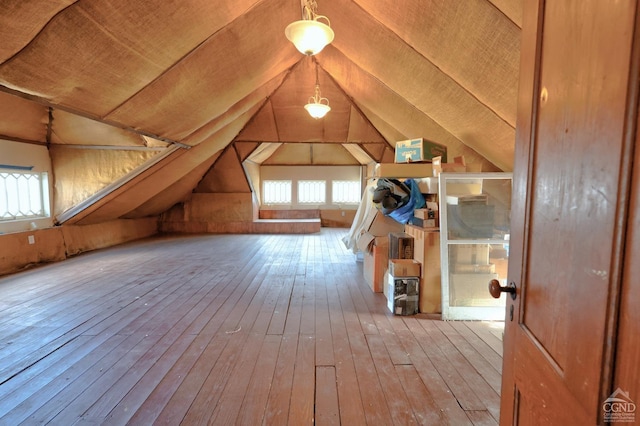 additional living space with wood-type flooring and lofted ceiling