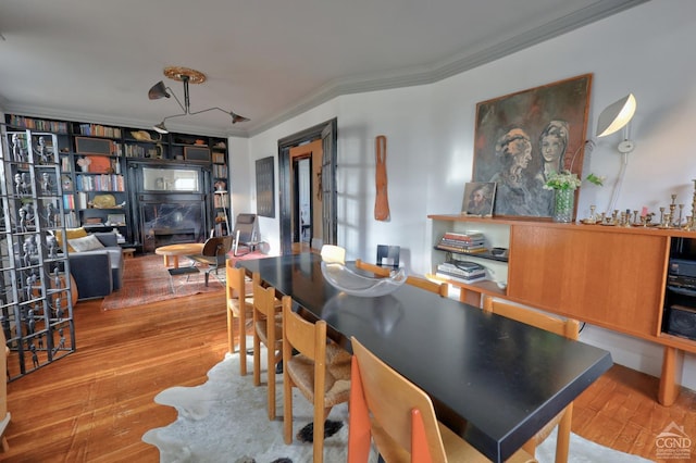 dining space featuring crown molding and wood finished floors