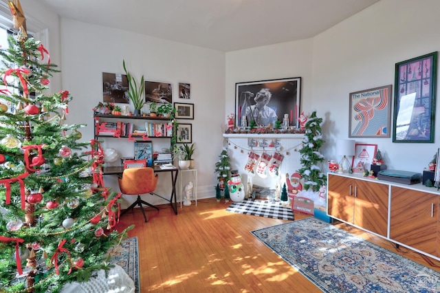 sitting room with wood finished floors and an office area